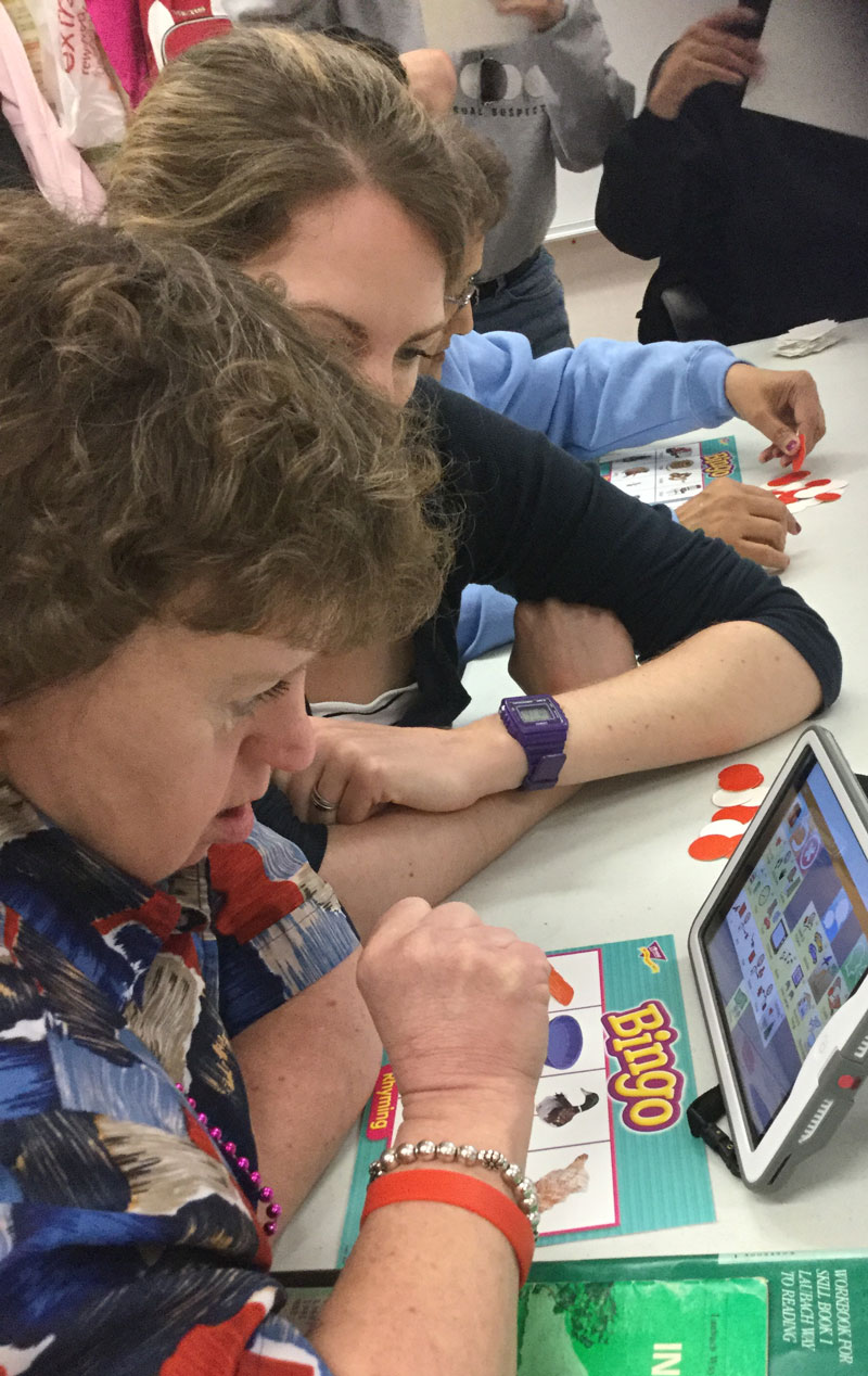 Photo of two ladies with an AAC device. Photo of two ladies with an AAC device.